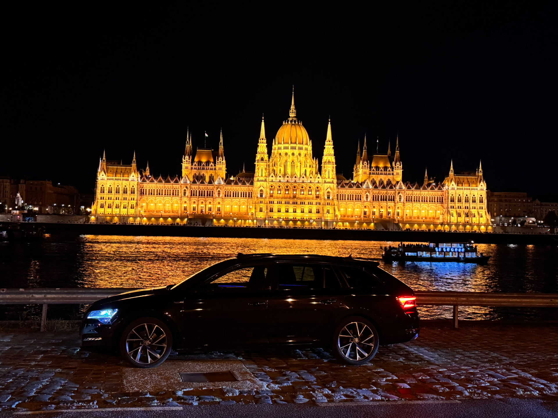 Hungarian Parliament illuminated at night beside the Danube in Budapest