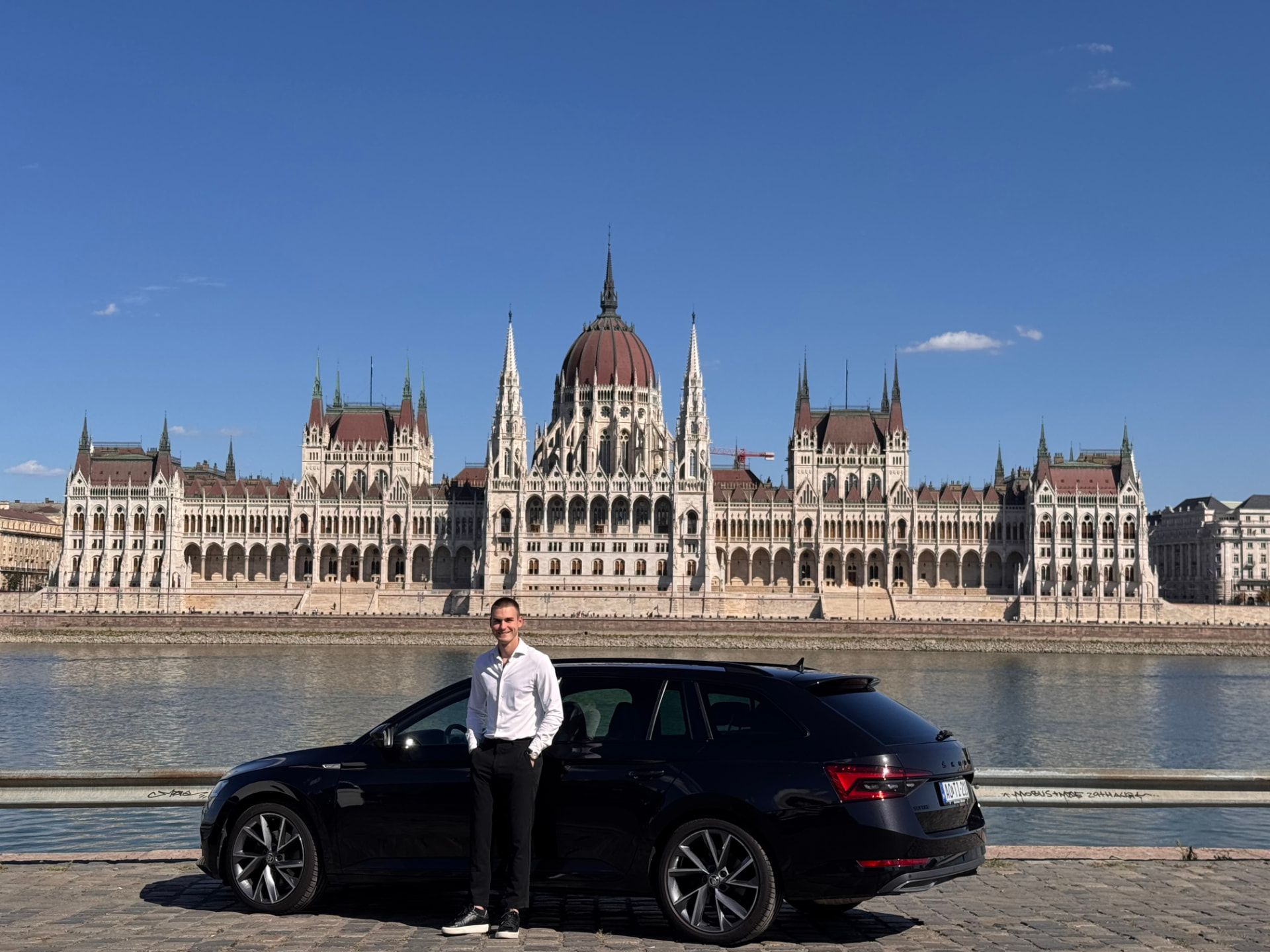 Krisztián Róka, private chauffeur, with his Škoda Superb in front of the Budapest Parliament